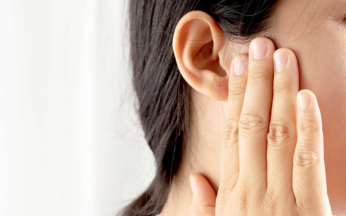 Woman pressing hand against ear