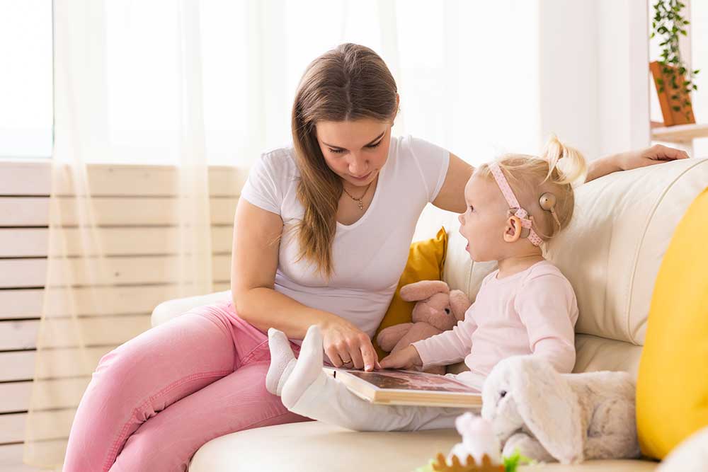 mother reading to her baby with a cochlear implant